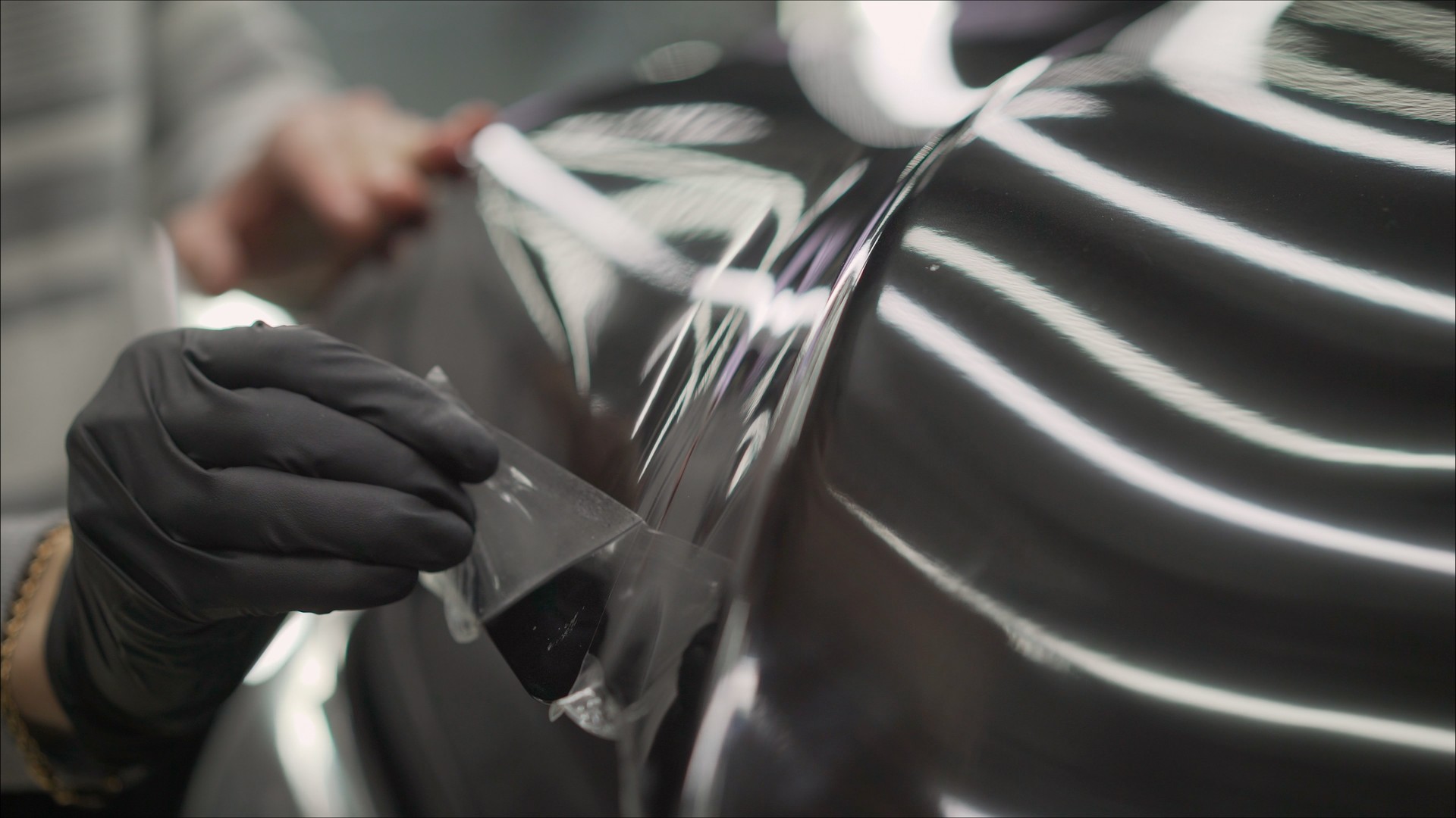 closeup peeling off protective film from a car